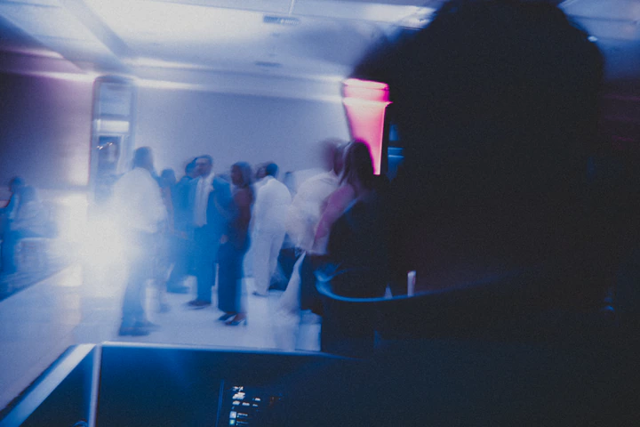 Guests gathered on the dance floor in blue and pink light
