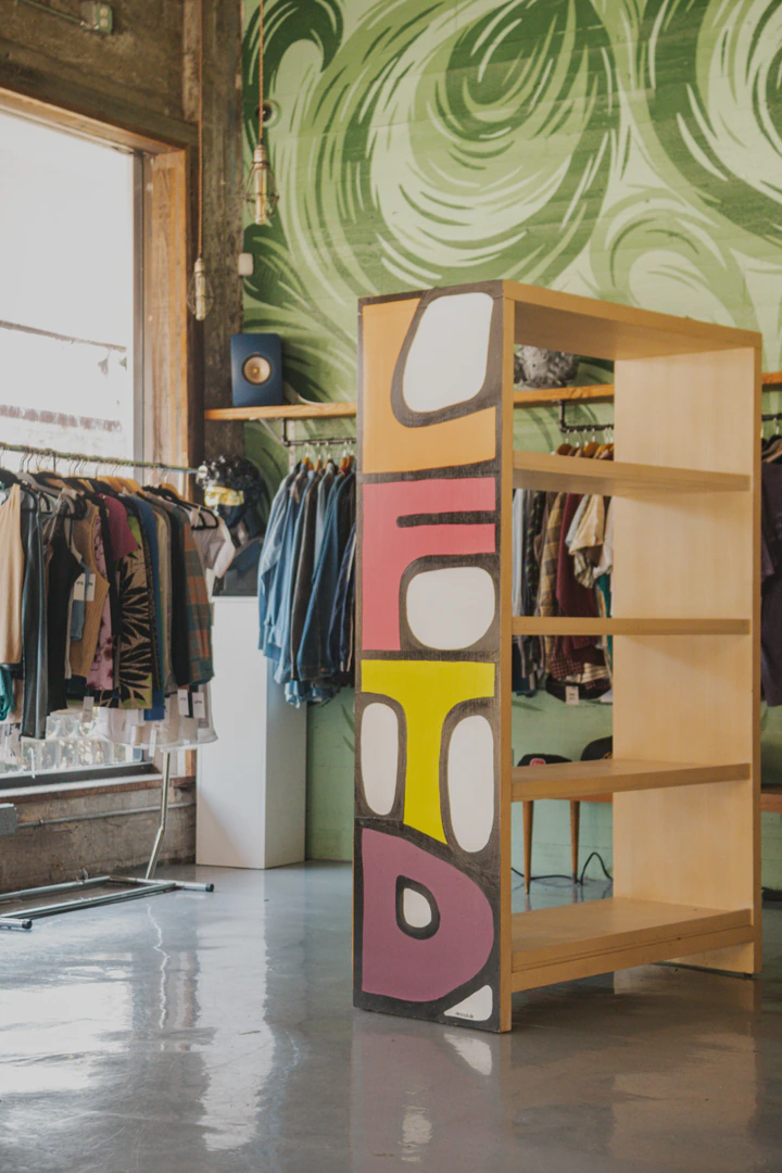 Painted LFTD shelf in a sunlit shop with a green mural