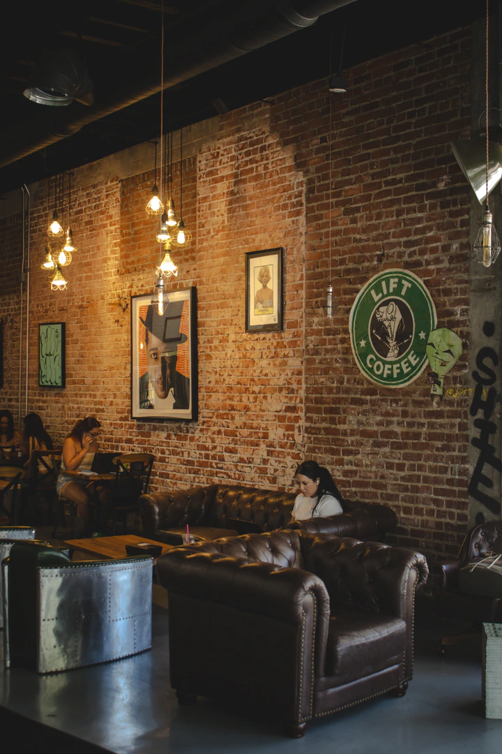 Brick-walled seating area with leather sofas and hanging lights