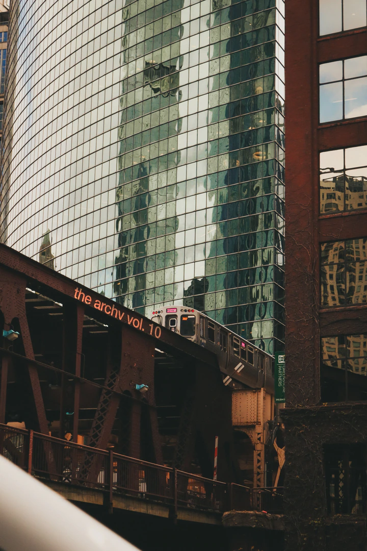An elevated train passing a glass tower