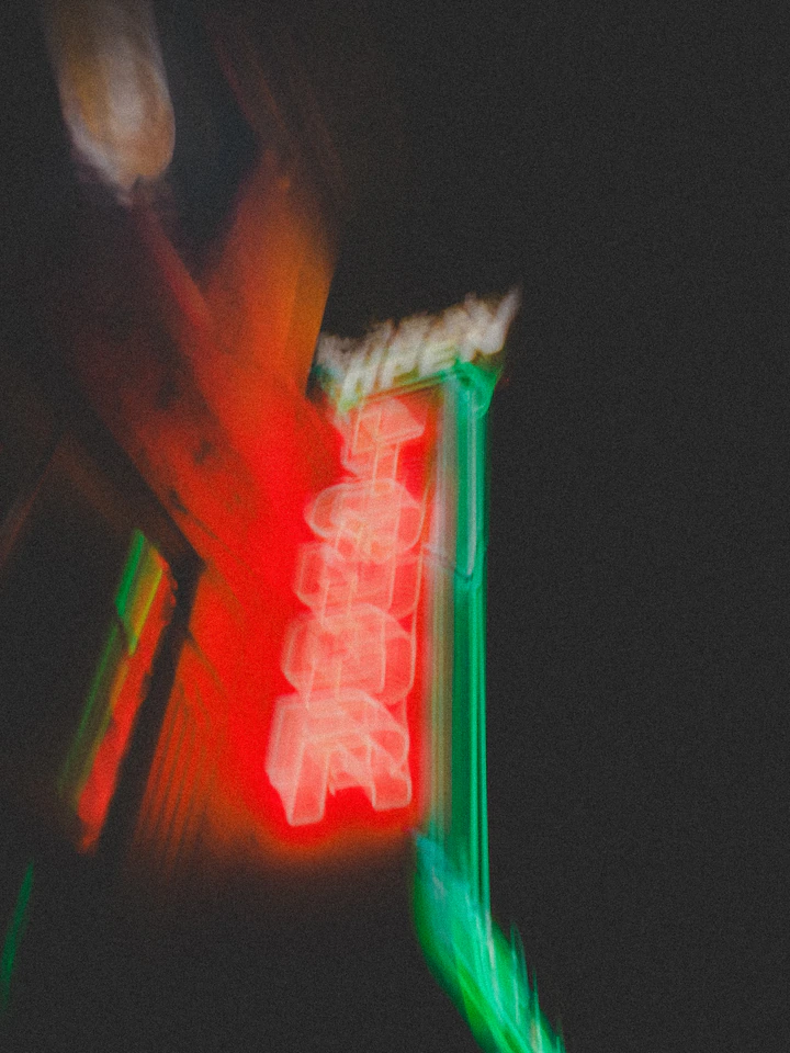 A red and green neon sign blurred with motion